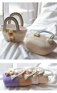 Detail of handmade cotton rope woven bag featuring rainbow handles and floral charms