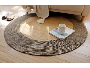 Texture détaillée d'un tapis rond en jute tissé avec cercles concentriques sur parquet