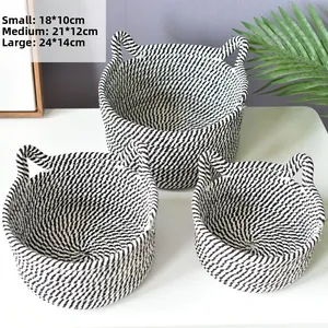 Three-piece set of woven cotton rope baskets in white and black with side handles
