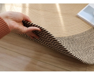 Détail de la texture et épaisseur du tapis rond en jute tressé main sur parquet bois