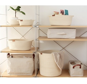 Minimalist cotton rope woven baskets and canvas boxes with leather handles on a wood shelf