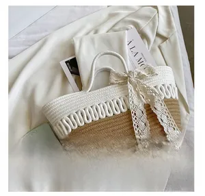 Detail shot of the contrast woven handbag with lace bow on a white jacket background