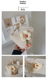 Detail of hand-woven cream mini bucket bag with yellow flower and cherry charm decoration