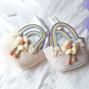 Handwoven cotton rope handbag with rainbow handle and decorative yellow fabric flowers