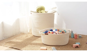 Detail view of woven cotton rope storage baskets set on jute rug in a bright room