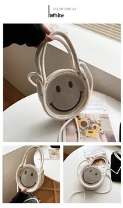 Détail d'un sac rond tissé blanc orné d'un motif visage souriant en sequins brillants