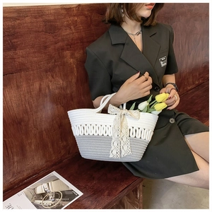 Detail of hand-woven tote bag with elegant lace bow and wave-hollow texture