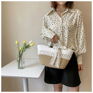 Detail of hand-woven tote bag with contrast stitching and delicate lace bow decoration