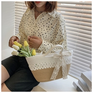 Close-up of handmade woven tote bag featuring lace bow detail and tulip flower decor