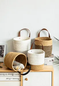 Detail of Nordic woven cotton rope storage baskets with leather handles in a home setting