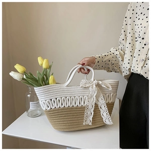 Detail of cream and khaki hand-woven cotton rope tote bag with lace bow accessory