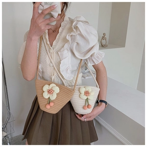 Detail of hand-woven cotton bucket bags in khaki and cream with 3D floral accents