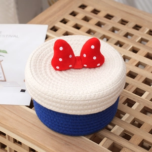 Handwoven cotton rope storage basket with red polka dot bow and dark blue base