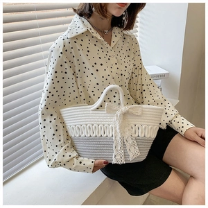 Detail of hand-woven cotton rope tote bag with lace bow and two-tone wave texture