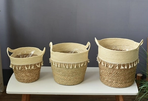 Detailed set of three woven seagrass baskets with boho tassels and plastic liners