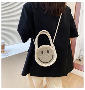 Détail d'un sac bandoulière rond en strass étincelants avec motif smiley classique