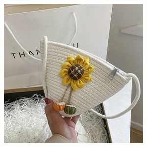 Detail view of woven sunflower crossbody bag with cotton rope straps and tassel charms