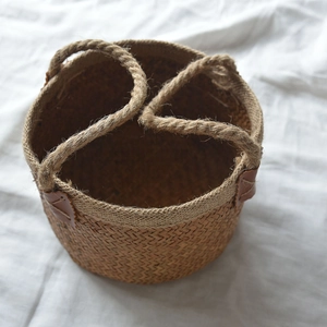 Macro view of woven seagrass basket detailing jute texture and brown leather accents