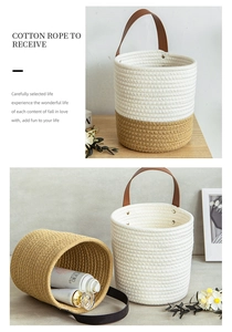 Detail of woven cotton rope storage basket with leather handles and two-tone color design