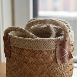 Detailed close-up of handmade seagrass basket with jute fabric rim and leather trim