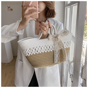 Detail view of handmade woven tote bag with contrast colors and elegant lace bow