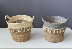 Detail view of woven straw storage baskets with tassel trim and waterproof plastic lining