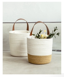 Detail of woven cotton storage basket showing the brown leather handle and metal rivets