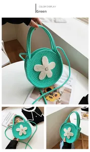 Détail du sac à main rond vert tressé avec fleur en perles et bandoulière amovible