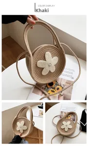 Détail du sac à main rond tissé kaki avec décoration florale en perles blanches