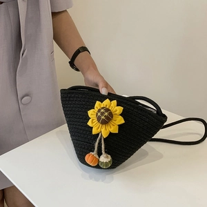 Handmade black woven straw bucket bag with sunflower accent and pumpkin charms for beach trips