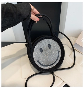 Détail du sac en paille noir avec un motif de smiley scintillant en strass argentés