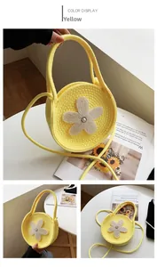 Détail du sac rond en tricot jaune avec un ornement floral central en perles blanches