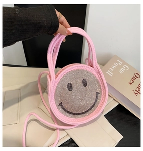 Détail d'un sac en paille rose avec motif sourire en strass et double poignée élégante