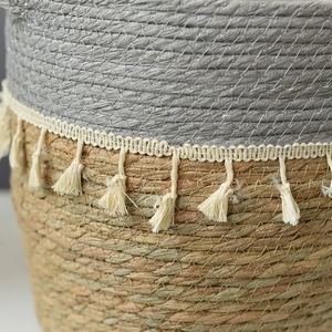 Detail of woven seagrass basket showing gray fiber texture and white fringe tassels