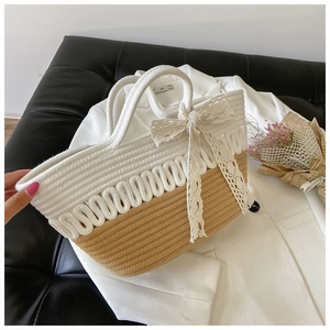 Detail of rope woven tote bag with contrast colors and a delicate white lace bow