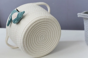 Detail showing the dense spiral weaving on the bottom of white cotton rope basket
