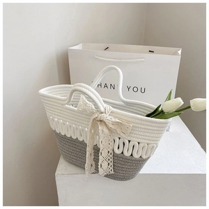 Detail of hand-woven cotton rope bucket bag with lace bow and two-tone color design