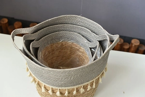 Detail view of woven straw planters with decorative tassels and clear plastic liners