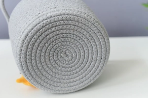 Detailed macro view of the circular base on a grey woven cotton rope storage basket
