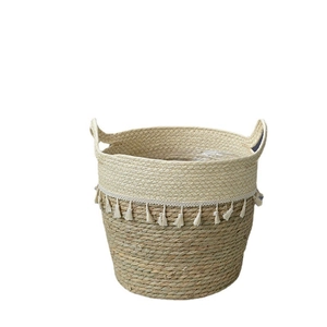 Extra large woven seagrass belly basket with white tassel fringe and side handles