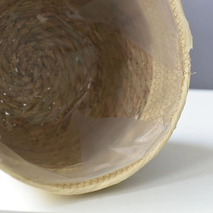 Macro detail of hand-woven seagrass basket featuring a waterproof plastic liner interior