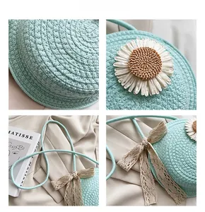 Close-up of sky blue round straw bag with white daisies and beige lace bow detail