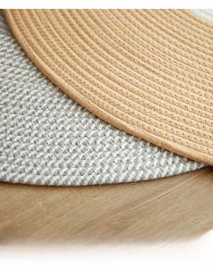 Detailed macro view of dual-layered thick spiral woven cotton rugs on wood floor