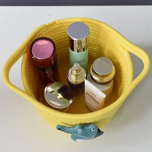 Top view of yellow woven cotton storage basket filled with cosmetics and toys