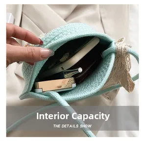 Detail view showing the spacious interior of the green woven straw crossbody bag