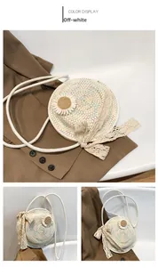 Detail of beige straw crossbody bag featuring woven daisy floral and lace bow accent