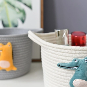 Detail of handwoven cotton rope storage basket featuring 3D cartoon animal decoration