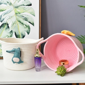 Detail of woven cotton rope baskets with cute crocodile motif and convenient handles