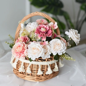 Handwoven wicker flower basket with pink roses, white tassels and elegant handle