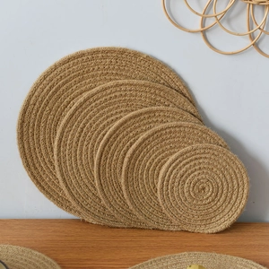 Detail of five round braided jute placemats showing natural texture and size variety